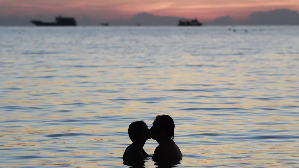 a-couple-kisses-during-sunset-by-the-island-of-koh-tao