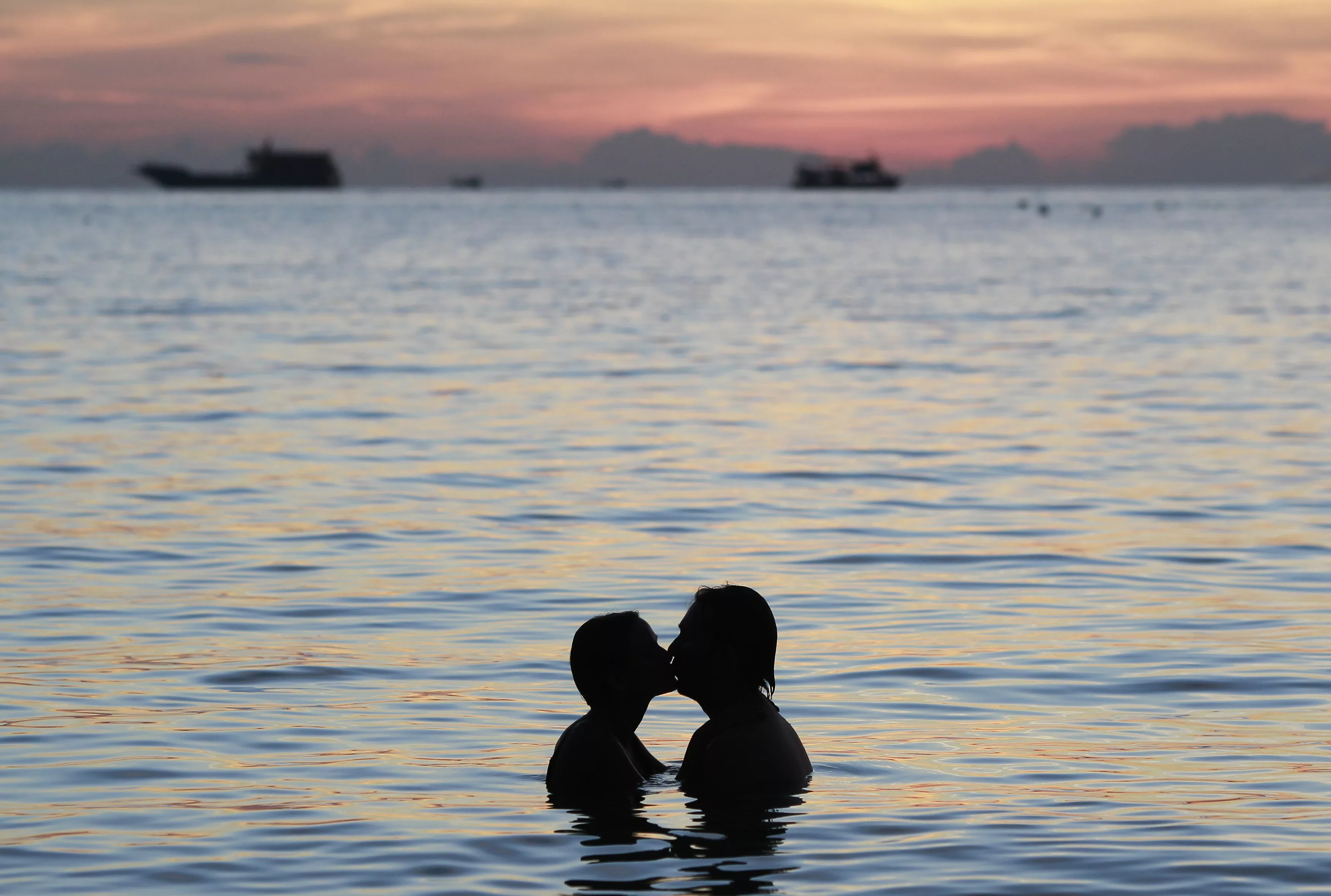 a-couple-kisses-during-sunset-by-the-island-of-koh-tao