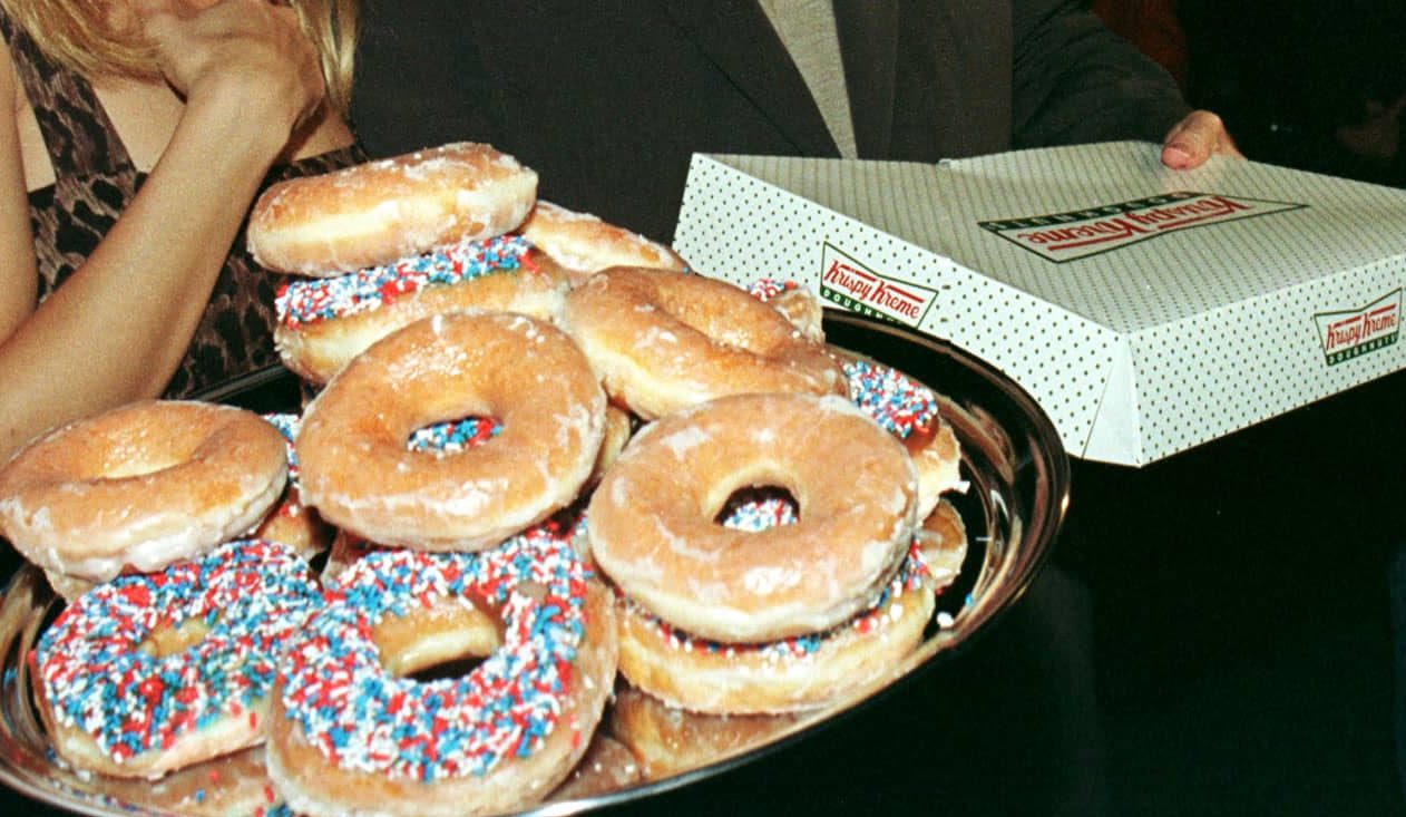 actor-john-travolta-r-and-wife-kelly-preston-c-accept-a-box-of-krispy-kreme-donuts-as-they-arri