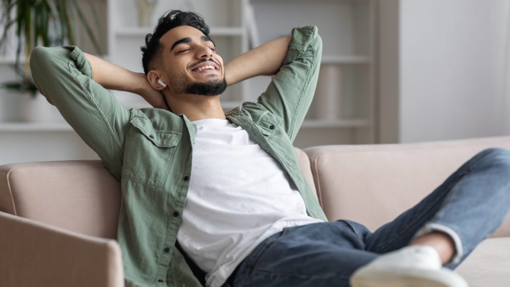 handsome-arab-guy-in-airpods-easrphones-listening-music-at-home