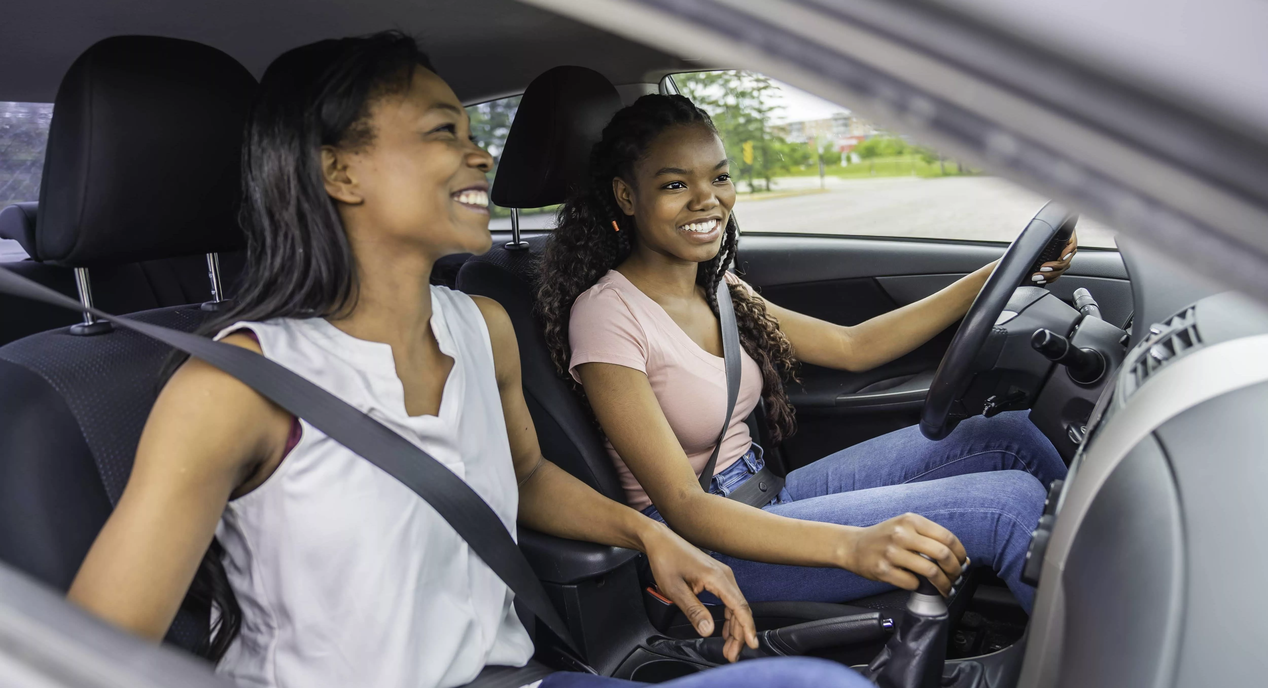 young-black-teenage-driver-seated-in-her-new-car-with-her-mother