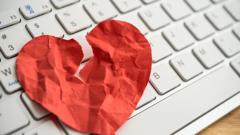 red-broken-heart-paper-on-white-keyboard-computer-background