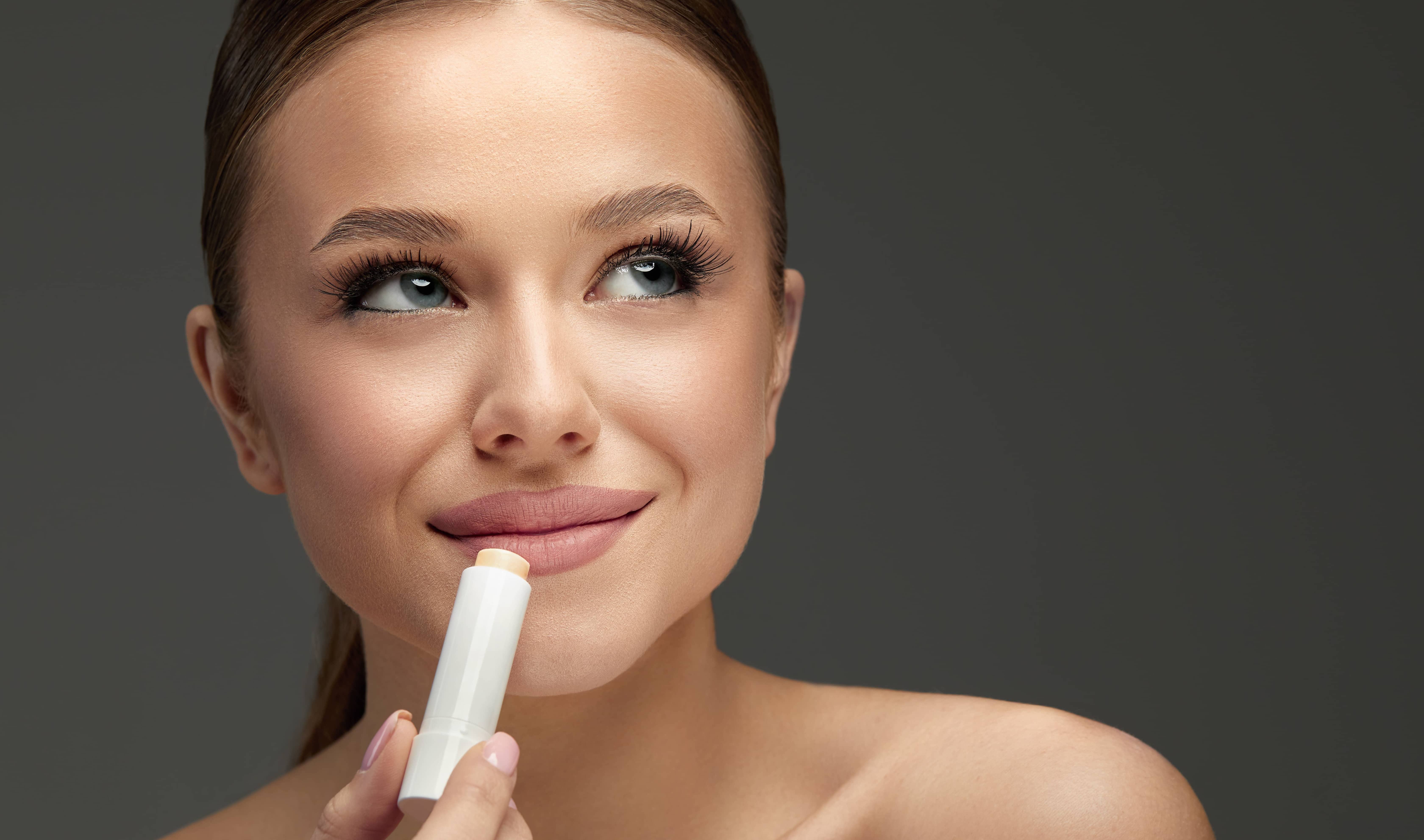 lips-skin-care-beautiful-woman-face-with-lips-applying-hygienic-lip-balm-lip-care-stick-closeup-of-female-face-with-soft-skin-putting-lip-protector-lipstick-on-beauty-cosmetics-concept