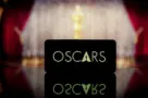 A smartphone displaying the Oscars logo against a blurred awards ceremony background. January 13^ 2025