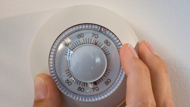 gettyrf_92222_adjustingthermostat