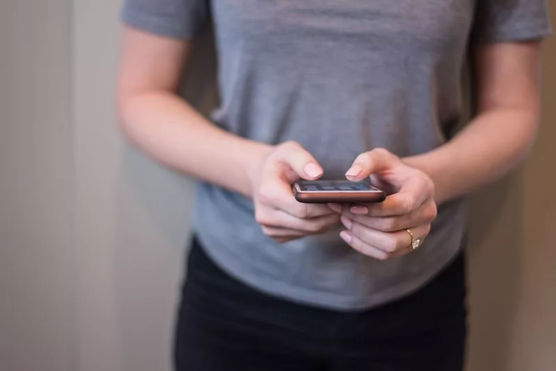 800px-holding_cell_phone_37176909002-madfish-digital84463