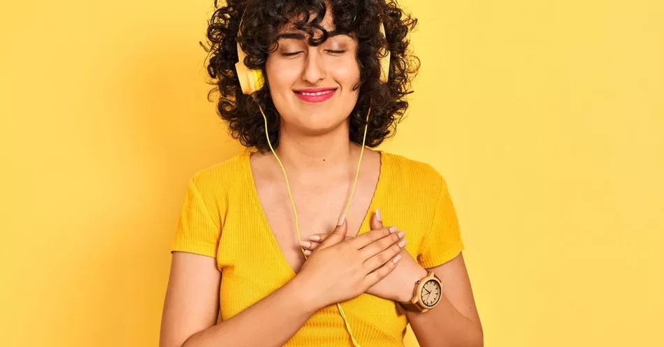 14806-woman-on-yellow-background-listening-to-worsh110250