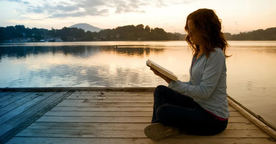 8939-woman-sitting-cross-legged-reading-bible-on-p779172