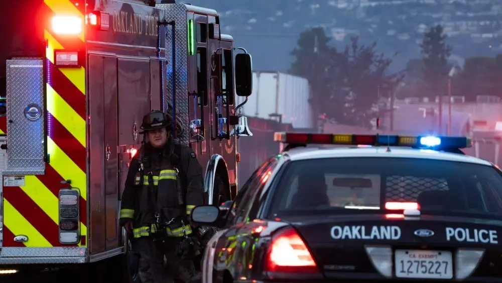 A firefighter stands outside a blaze at a transfer station in East Oakland. Two RVs caught fire in the enclosed lot. Oakland^ California - April 18^ 2026