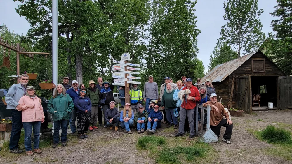 Pioneers-of-Alaska-pose-with-the-new-signpost-they-erected-designating-distances-from-McCarthy-Alaska-to-other-Pioneer-Igloos-within-the-state.