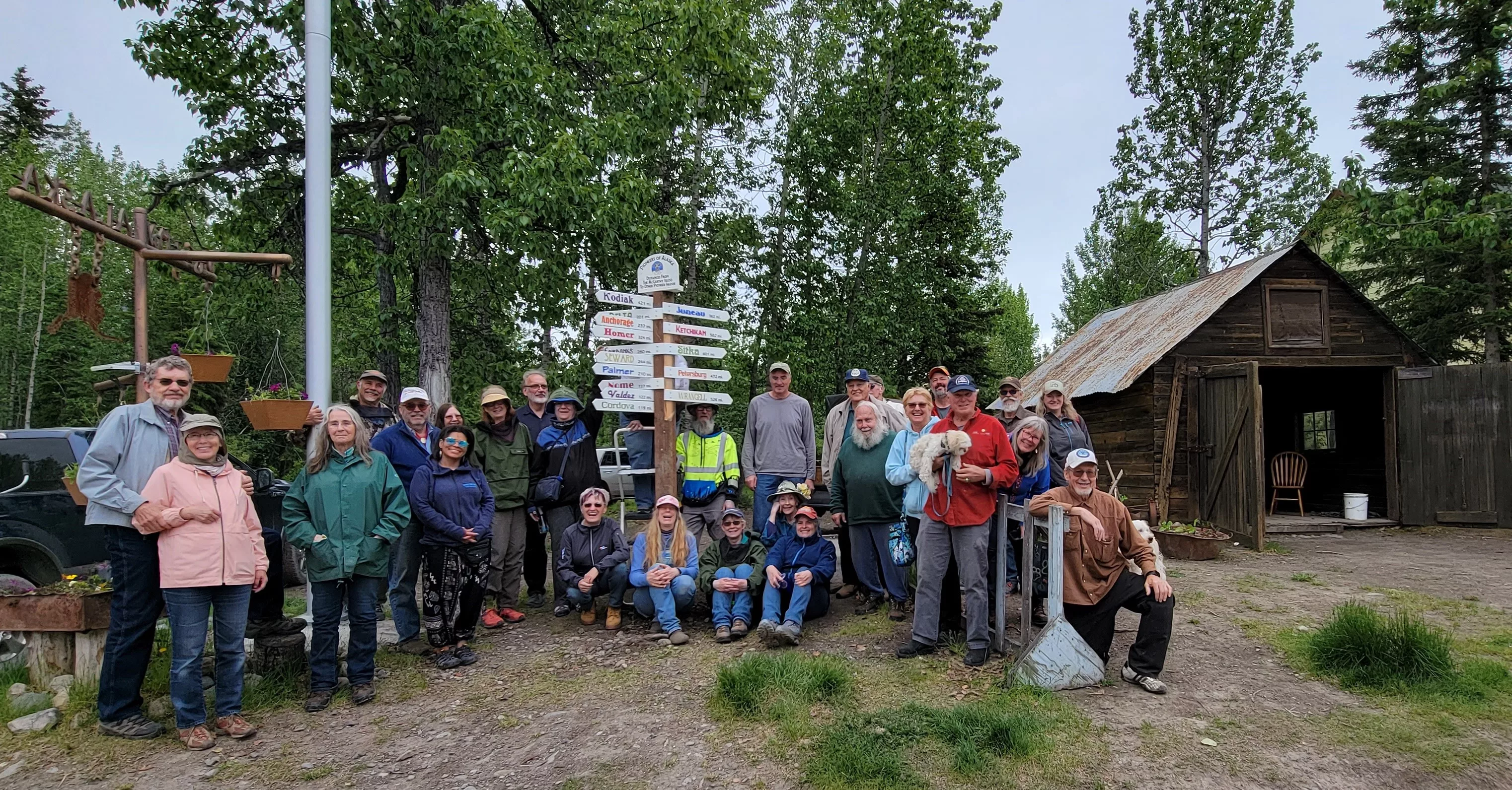 Pioneers-of-Alaska-pose-with-the-new-signpost-they-erected-designating-distances-from-McCarthy-Alaska-to-other-Pioneer-Igloos-within-the-state.