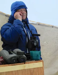 Craig George talks on a cellphone with his wife Cyd Hanns while he takes a break from glassing for migrating bowhead whales north of Utqiagvik in May 2010. Photo by Ned Rozell.