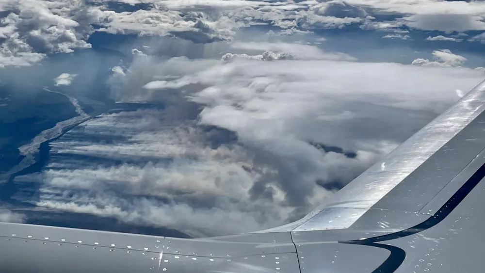 A wildfire creeps toward a glacial river in Alaska on this window-seat view from a Boeing 737 flying from Fairbanks to Seattle on Aug. 6, 2023. Photo by Ned Rozell.