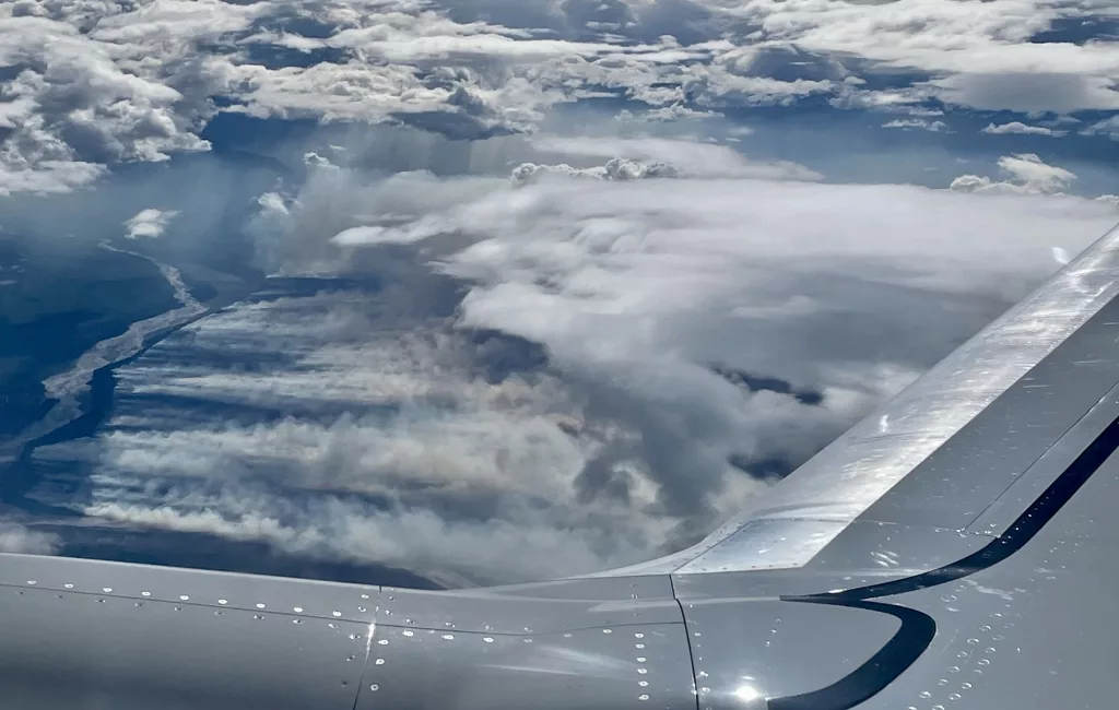 A wildfire creeps toward a glacial river in Alaska on this window-seat view from a Boeing 737 flying from Fairbanks to Seattle on Aug. 6, 2023. Photo by Ned Rozell.