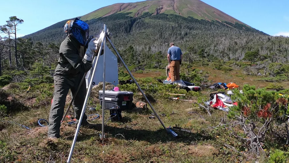 Alaska Volcano Observatory field technician Max Kaufman welds a new GNSS antenna monument at one of the observatory's new volcano monitoring sites on Mount Edgecumbe in late August 2023. Photo by Kax Kaufman..