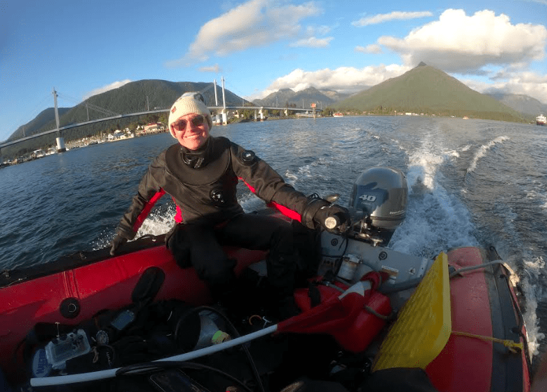 Oregon State University biologist and diver Sarah Gravem motors past Sitka on her way to a kelp forest she is monitoring. Photo by Jake Metzger..