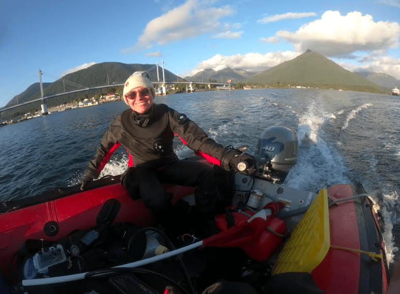 Oregon State University biologist and diver Sarah Gravem motors past Sitka on her way to a kelp forest she is monitoring. Photo by Jake Metzger..