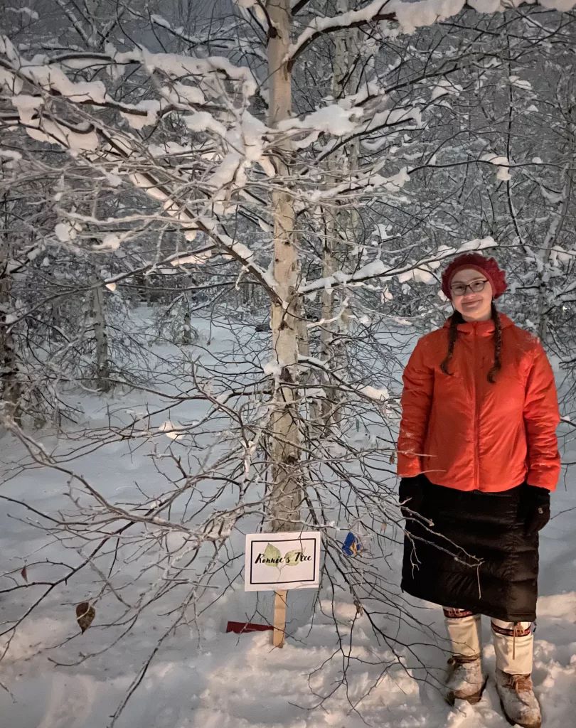 2. Annemarie Timling stands near a birch tree she helped choose to honor her father Ronnie Daanen, who died in a helicopter crash in July 2023. Photo by Ned Rozell.