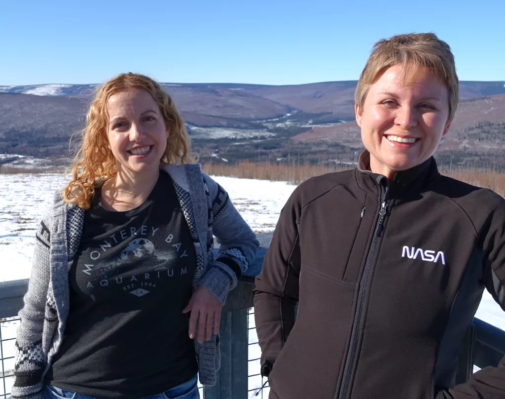 Astrophysicists Lindsay Glesener, left, and Sabrina Savage enjoy the sunshine on an observation deck at the Neil Davis Science Center on a hilltop at Poker Flat Research Range north of Fairbanks. Photo by Ned Rozell.