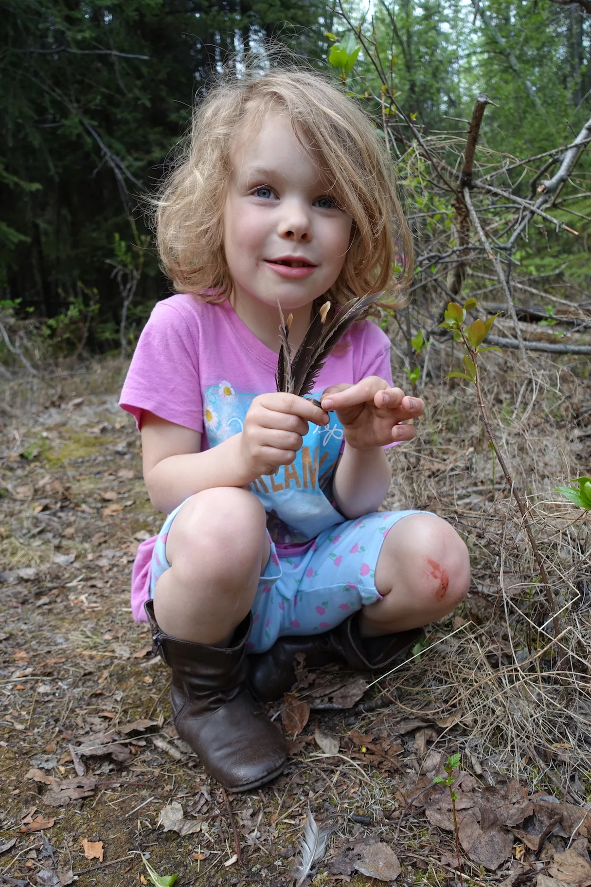 Rose Bulger, 6, holds grouse feathers she found during a family science expedition on the UAF campus.