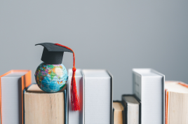 Graduation cap positioned on a globe and books