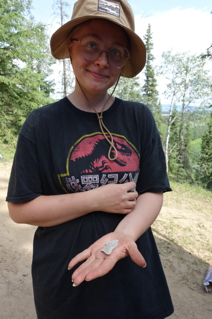 Lucy Ksiazek, who is helping with an archaeological dig this summer in Delta Junction, holds a flake of human-worked rock that she found at a level that suggests someone left it there more than 12,000 years ago. Photo by Ned Rozell.