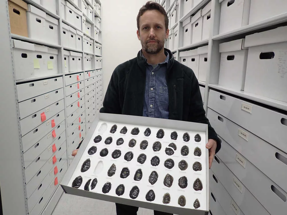 Archaeologist Jeff Rasic holds a tray of obsidian tools found in the Nogahabara Dunes west of the Koyukuk River. Photo by Ned Rozell.