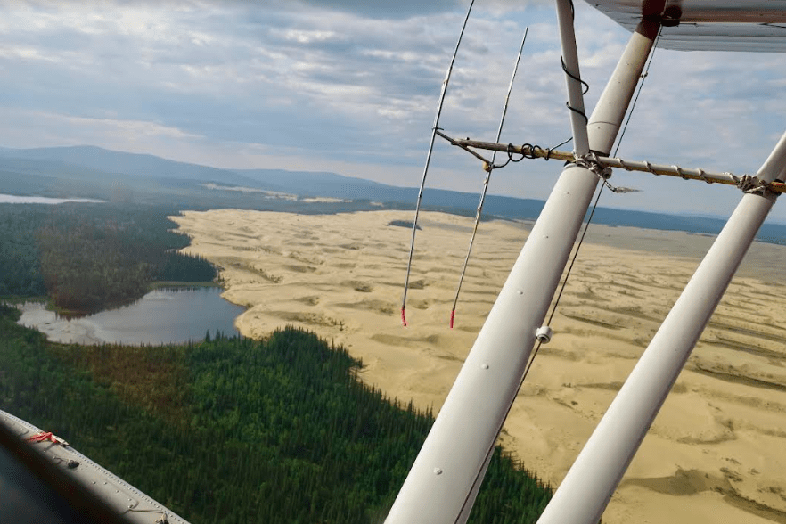 The Nogahabara Dunes spill into a lake 35 miles west of the village of Huslia as seen from the back seat of a Super Cub piloted by Brad Scotton of the U.S. Fish and Wildlife Service based in Galena. Photo by Ned Rozell.