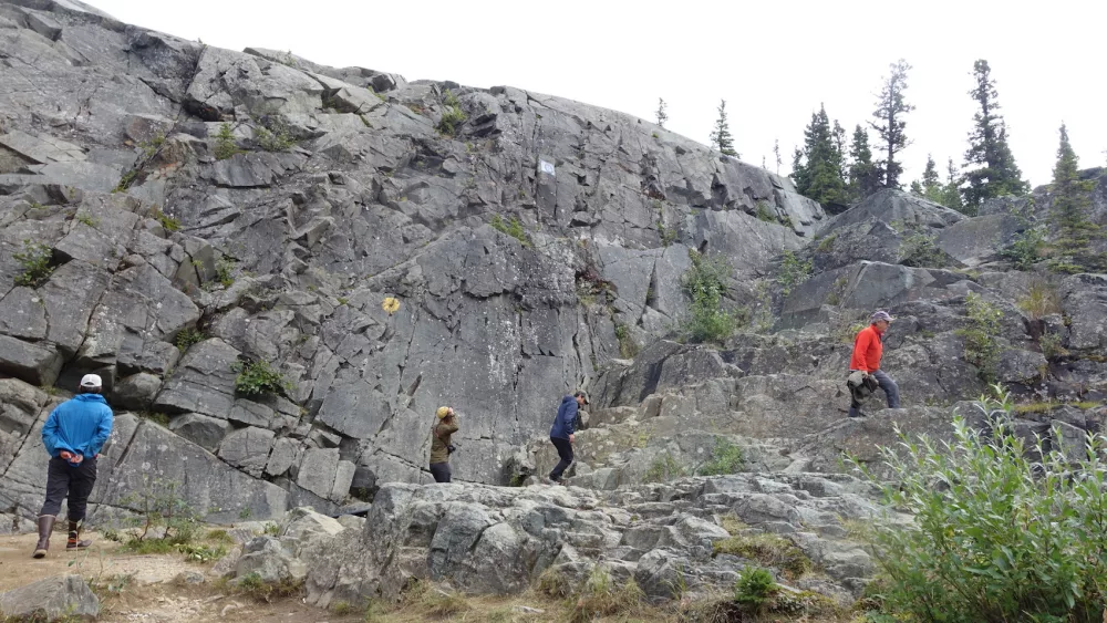 Scientists scale a rock face south of Delta Junction that was scoured bare by floodwaters from the failure of a glacial ice dam hundreds of years ago. Photo by Ned Rozell.