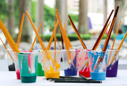 Paint brushes in cups of water