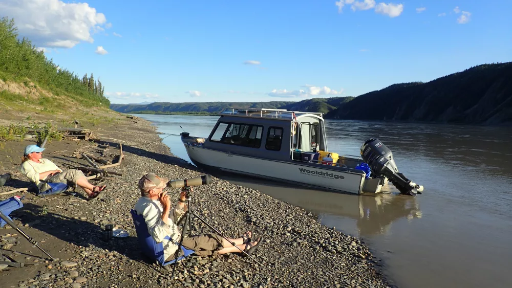 Chris Florian, left, and Skip Ambrose scan a cliffside across the upper Yukon River looking for peregrine falcons on July 13, 2018. Photo by Ned Rozell.