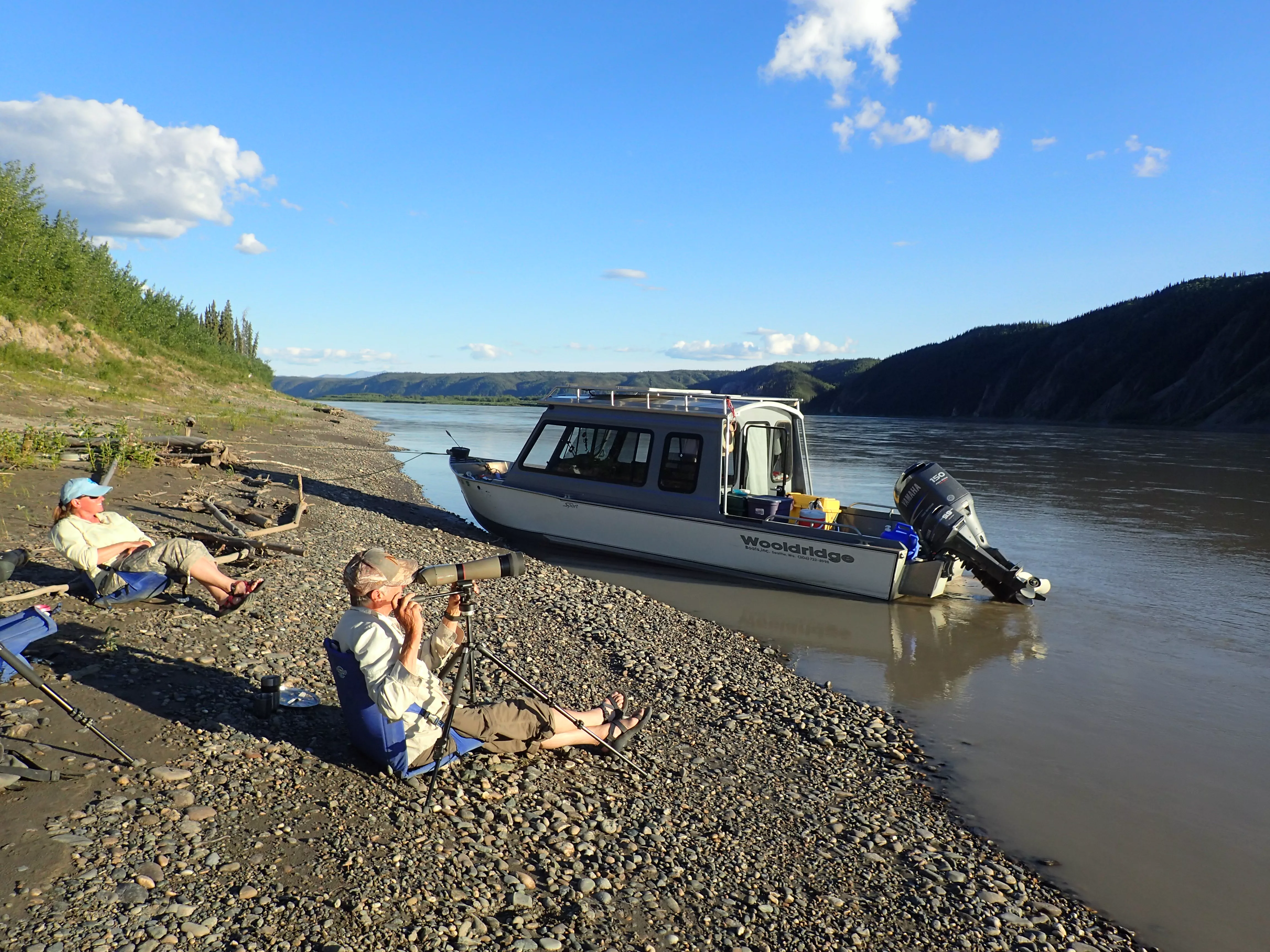 Chris Florian, left, and Skip Ambrose scan a cliffside across the upper Yukon River looking for peregrine falcons on July 13, 2018. Photo by Ned Rozell.