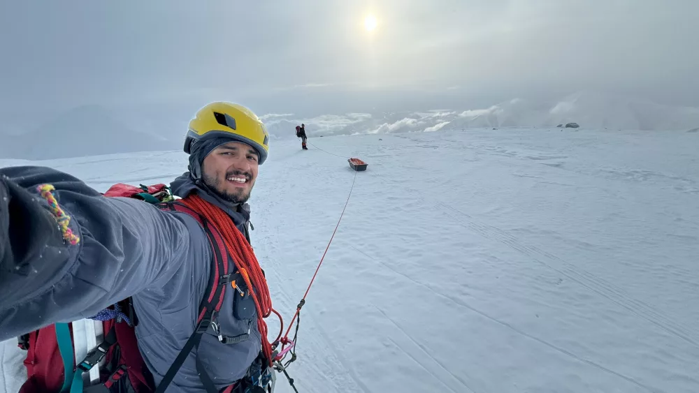 Roger Jaramillo walks on crampons while roped to a sled and his partner Matthew Crisafi-Lurtsema. The pair climbed Denali and sampled microplastics along their route in June, 2024. Photo by Roger Jaramillo.