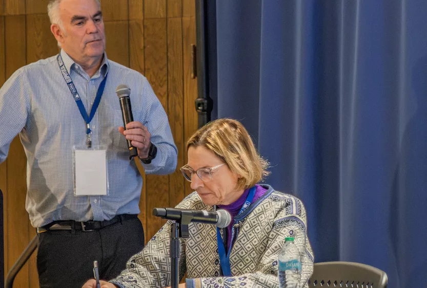 Mark Myers, head of the U.S. Arctic Research Commission, leads a discussion on the potential of geologic hydrogen at a conference in Fairbanks recently. Alaska State Senator Cathy Giessel takes notes. Photo by Eric Marshall.