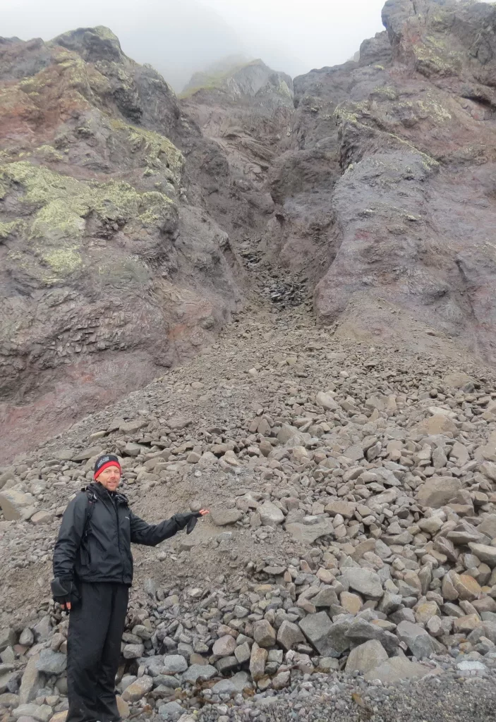 Ned Rozell pauses at the site of a rock avalanche on St. Matthew Island in the Bering Sea during a 2012 visit. Photo by Rich Kleinleder.