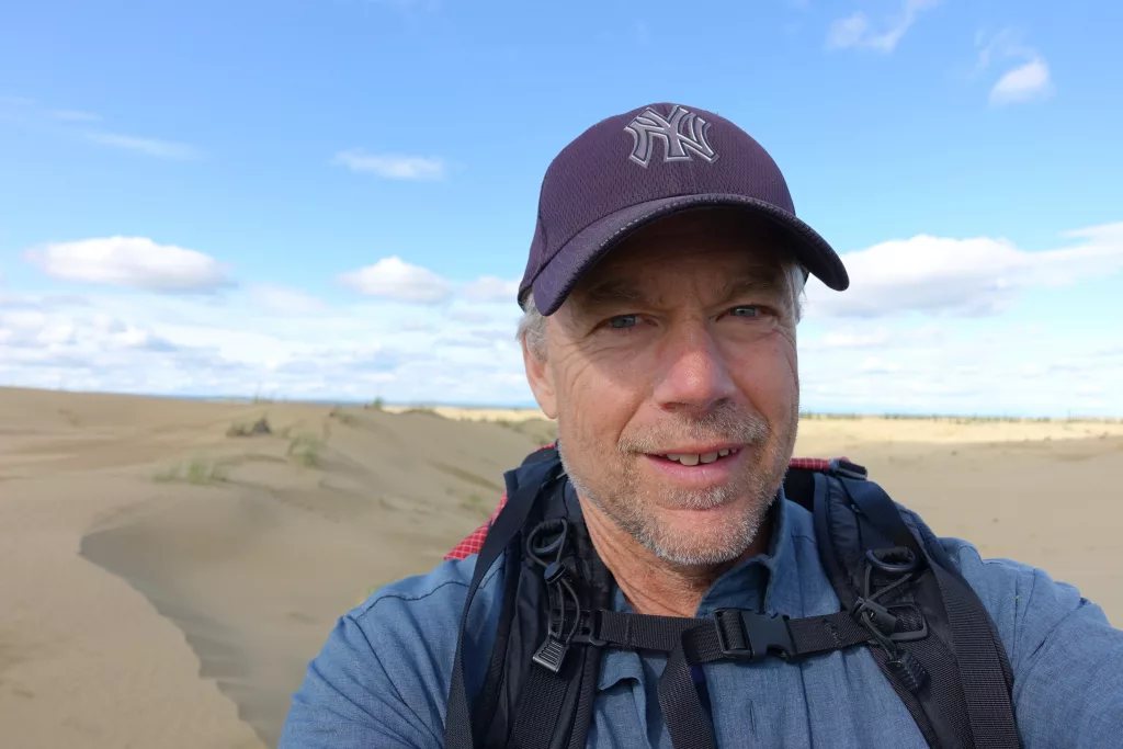 Ned Rozell hikes a sandy ridge at western Alaska’s Nogahabara Dunes in summer 2024. Photo by Ned Rozell.