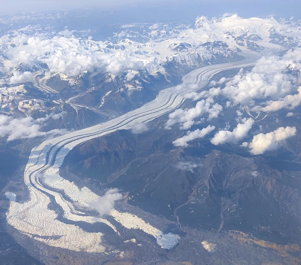 The Klutlan Glacier flows into the Yukon from Alaska’s Mount Bona, the highest peak in the photo, and Mount Churchill, the high ridge to the right of Bona. Image courtesy the Alaska Volcano Observatory/Alaska Division of Geological and Geophysical Surveys.