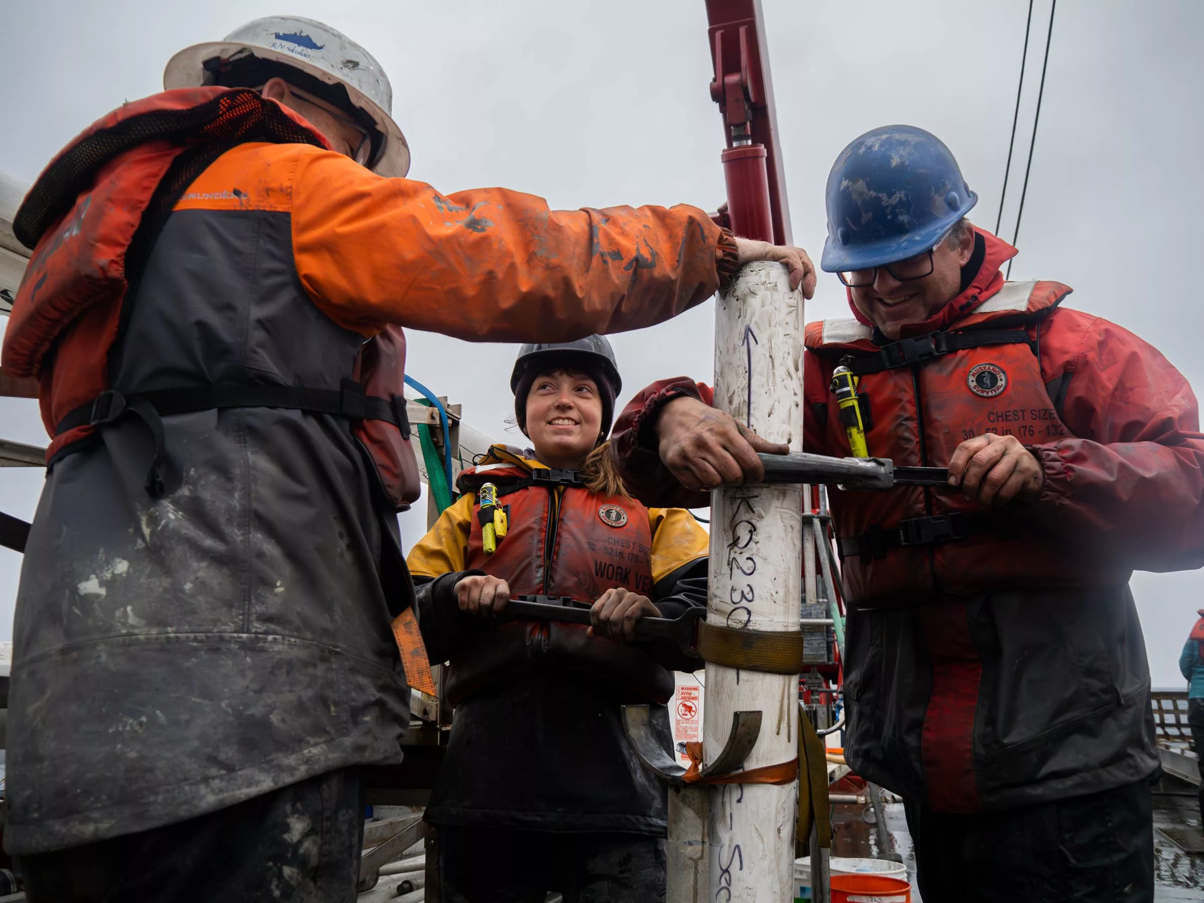 UAF master’s degree student Sara Datson, facing camera, helps retrieve a core of the ocean floor west of Nome during a summer 2023 cruise of the University of Alaska Fairbanks research ship Sikuliaq. Photo by Natalie Buttner.