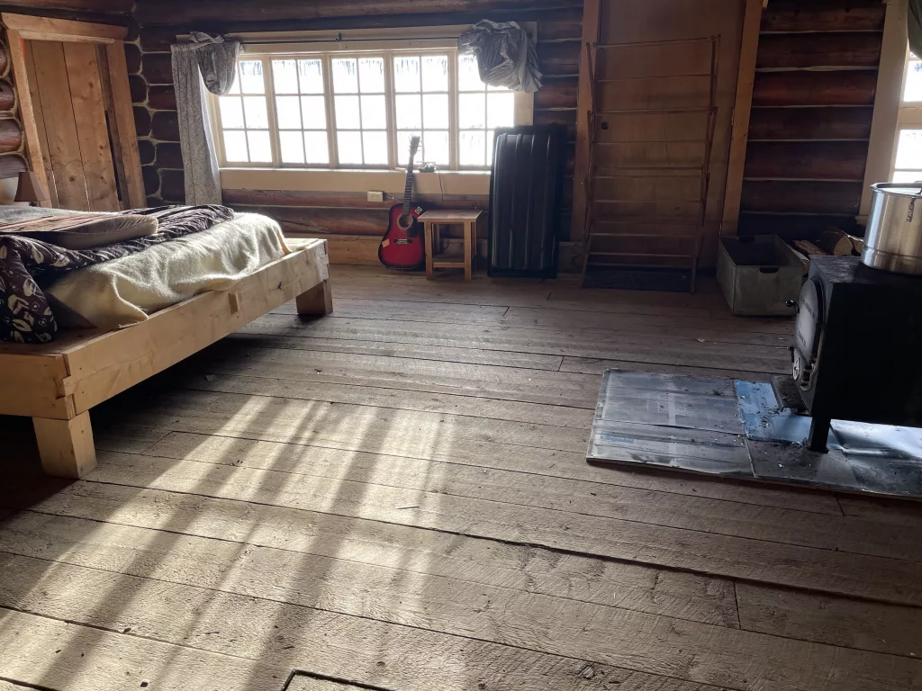 Sun shines on an interior floor of Tolovana Roadhouse, a “hospitality stop” in the 2025 Iditarod sled dog race. Photo by Ned Rozell.