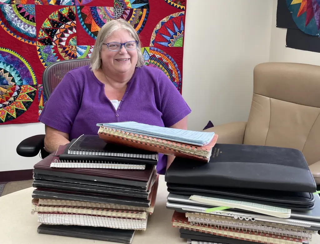 In June 2025, Kathe Rich sits in her office at Poker Flat Research Range behind notebooks she has filled with details of her 35 years at the rocket-launching facility. Photo by Ned Rozell.