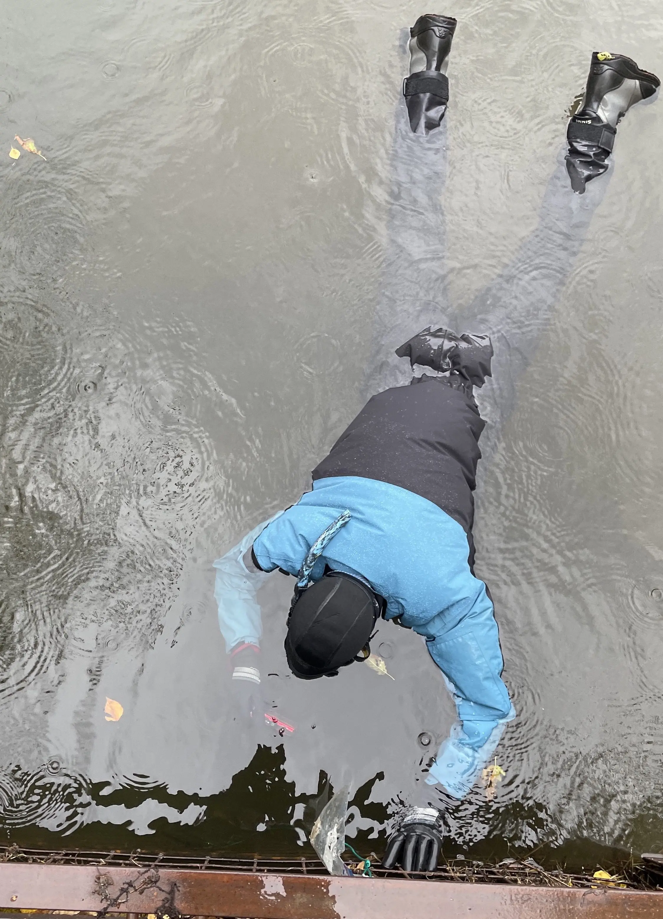 3. Raven Dawson floats in a dry suit in September 2025 as he attempts to photograph tiny king salmon within a culvert that leads from a slough to the upper Chena River. Photo by Ned Rozell.
