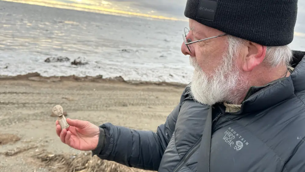 Rick Knecht holds a human figure that he found on the beach near the village of Quinhagak on Oct. 24, 2025. Photo by Alice Bailey.