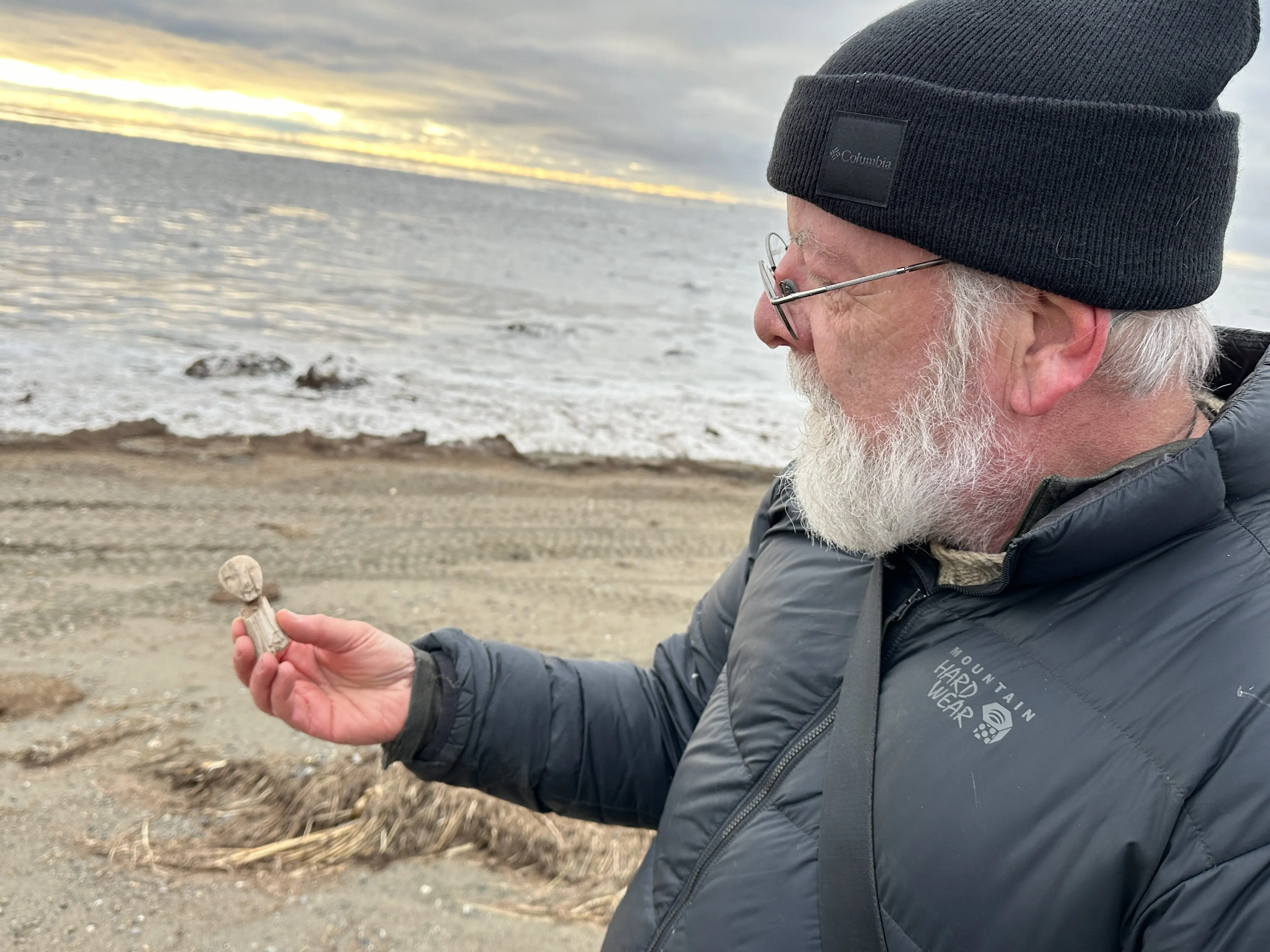 Rick Knecht holds a human figure that he found on the beach near the village of Quinhagak on Oct. 24, 2025. Photo by Alice Bailey.