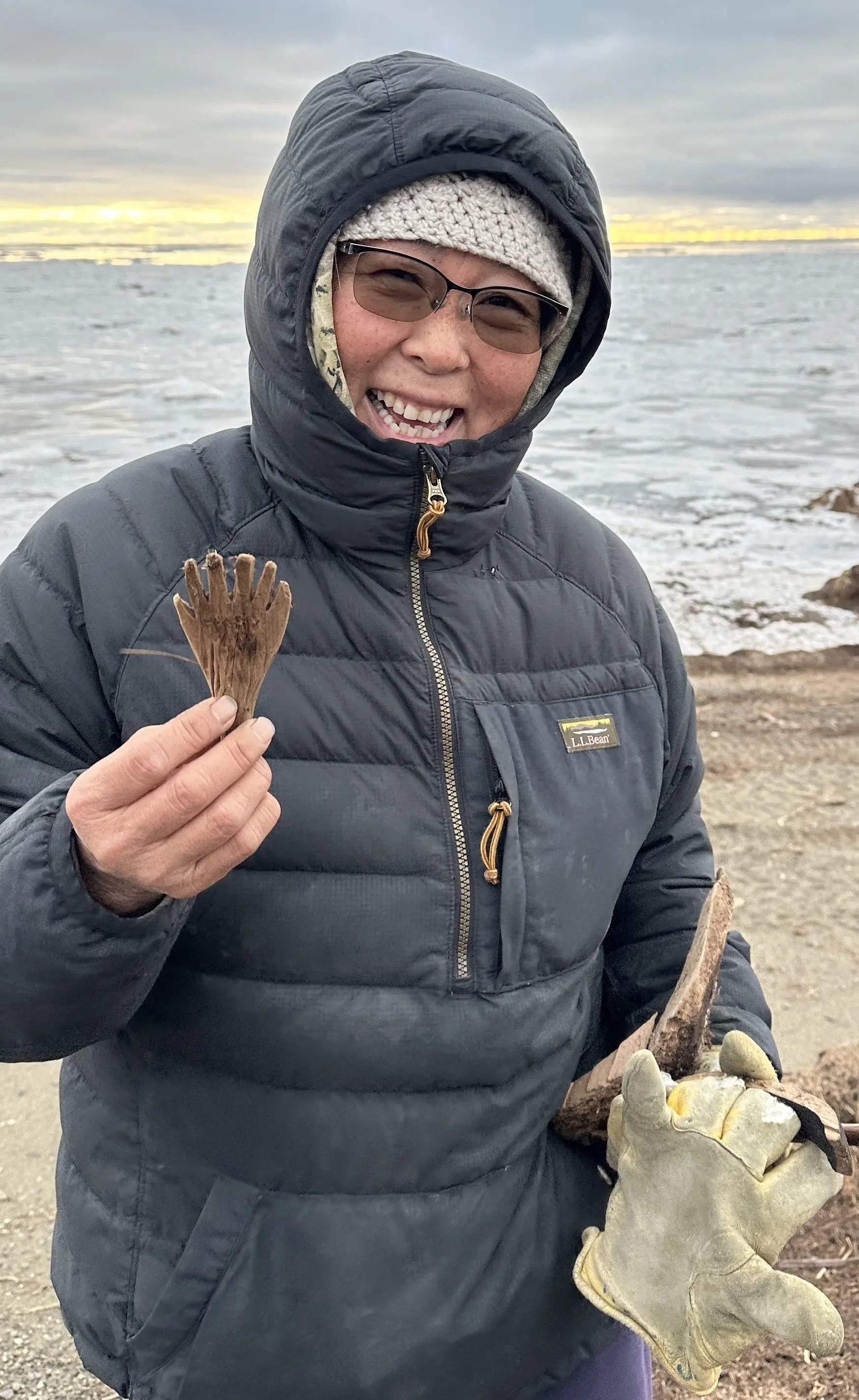 Quinhagak resident Sarah Brown holds a mask attachment she found on the beach on Oct. 24, 2025. This item might represent a hand or fin of an animal or spirit being. Photo by Alice Bailey.