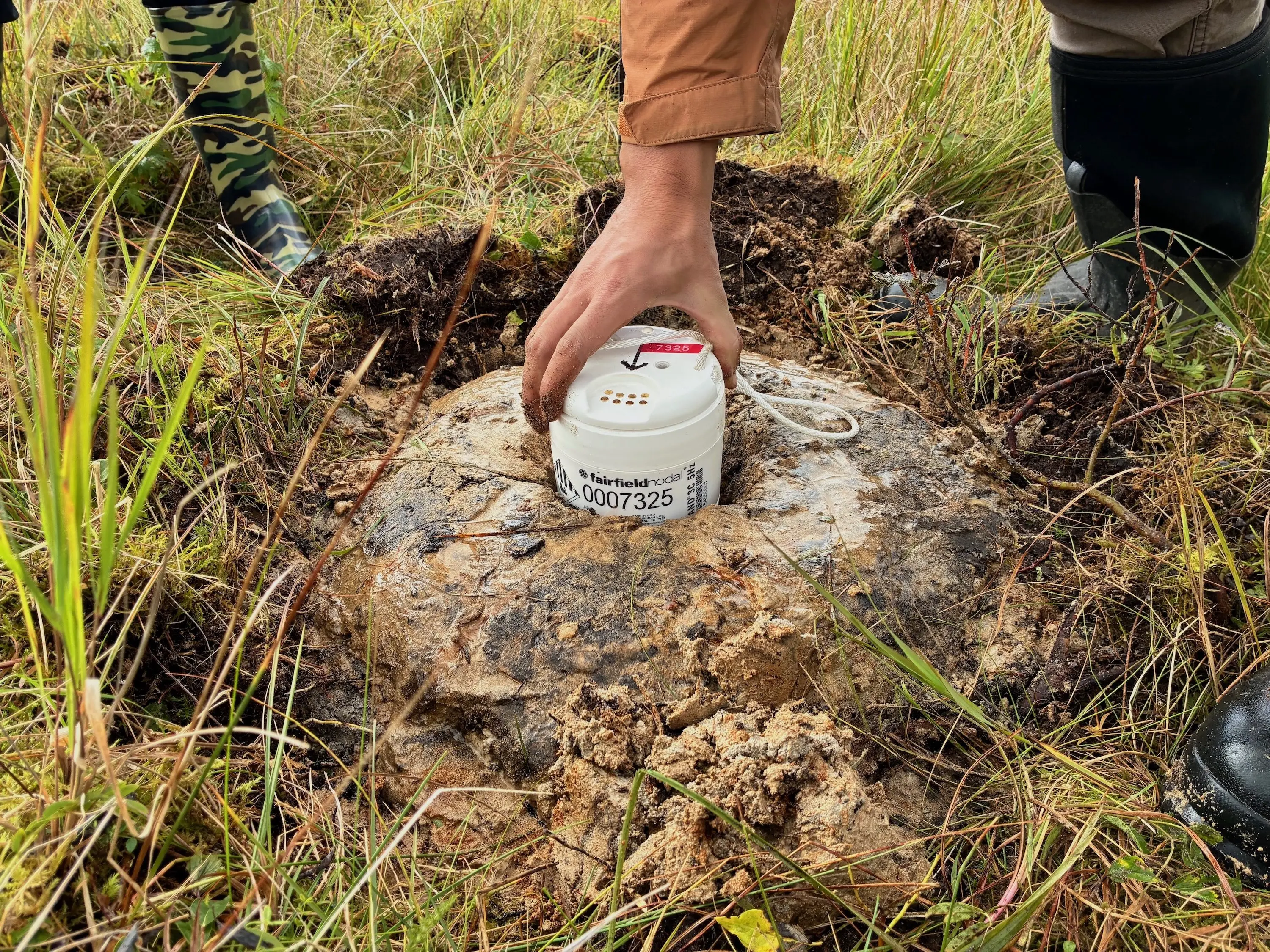 A seismic sensor resting in a “mud pie” on Kodiak Island in September 2025. Photo by Cade Quigley