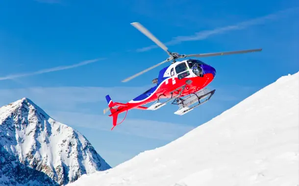 Helicopter flying over snowy mountain
