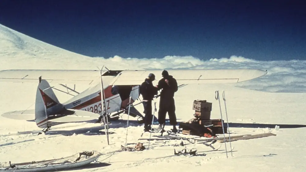 Carl Benson, right, and pilot Jack Wilson of Copper Center confer after landing near the summit of 14,000-foot Mount Wrangell. Photo courtesy of the UAF Geophysical Institute.