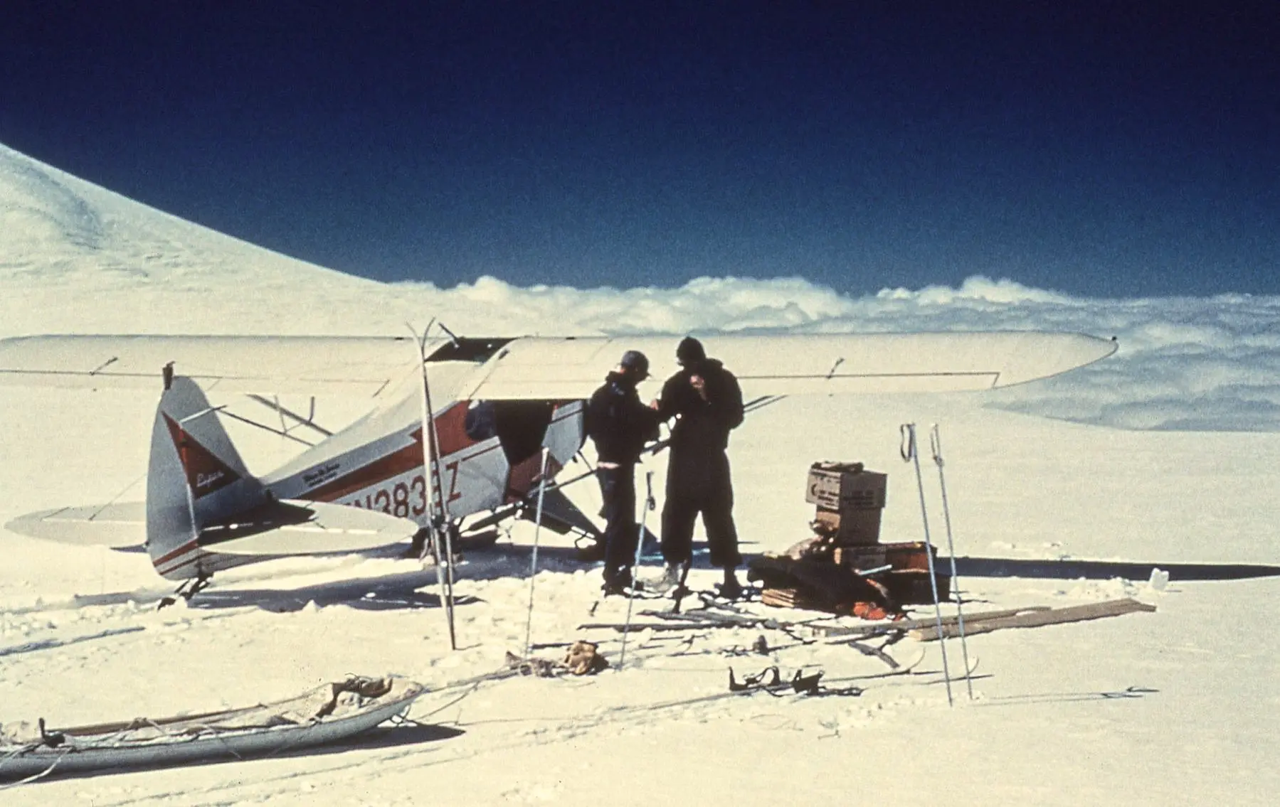 Carl Benson, right, and pilot Jack Wilson of Copper Center confer after landing near the summit of 14,000-foot Mount Wrangell. Photo courtesy of the UAF Geophysical Institute.