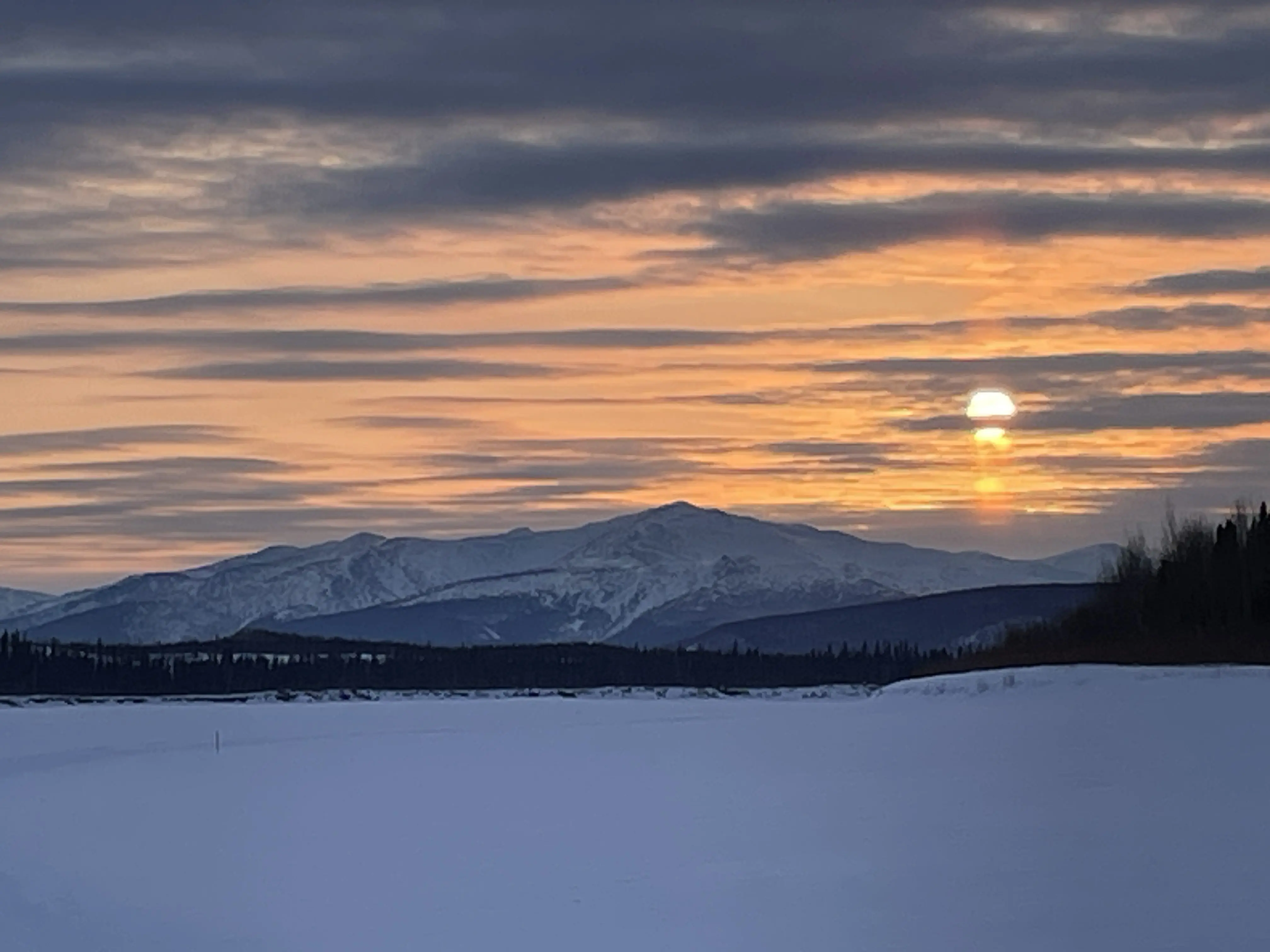 The sun sets over the Kokrine Hills between Ruby and Tanana in this image from a Yukon River campsite packed into the snow by Ned Rozell and Forest Wagner. Photo by Ned Rozell.