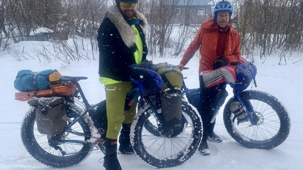 Forest Wagner, left, and Ned Rozell reach the village of Kaltag on the Yukon River on April 7, 2026. They are attempting to pedal fat bikes from Fairbanks to Nome. Photo by Chris Carlson.